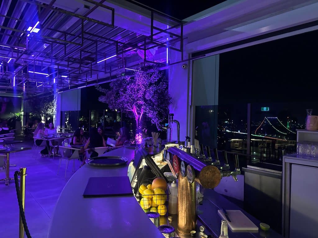 Iris Rooftop Bar at Hotel X Brisbane with ambient purple lighting and views of Story Bridge
