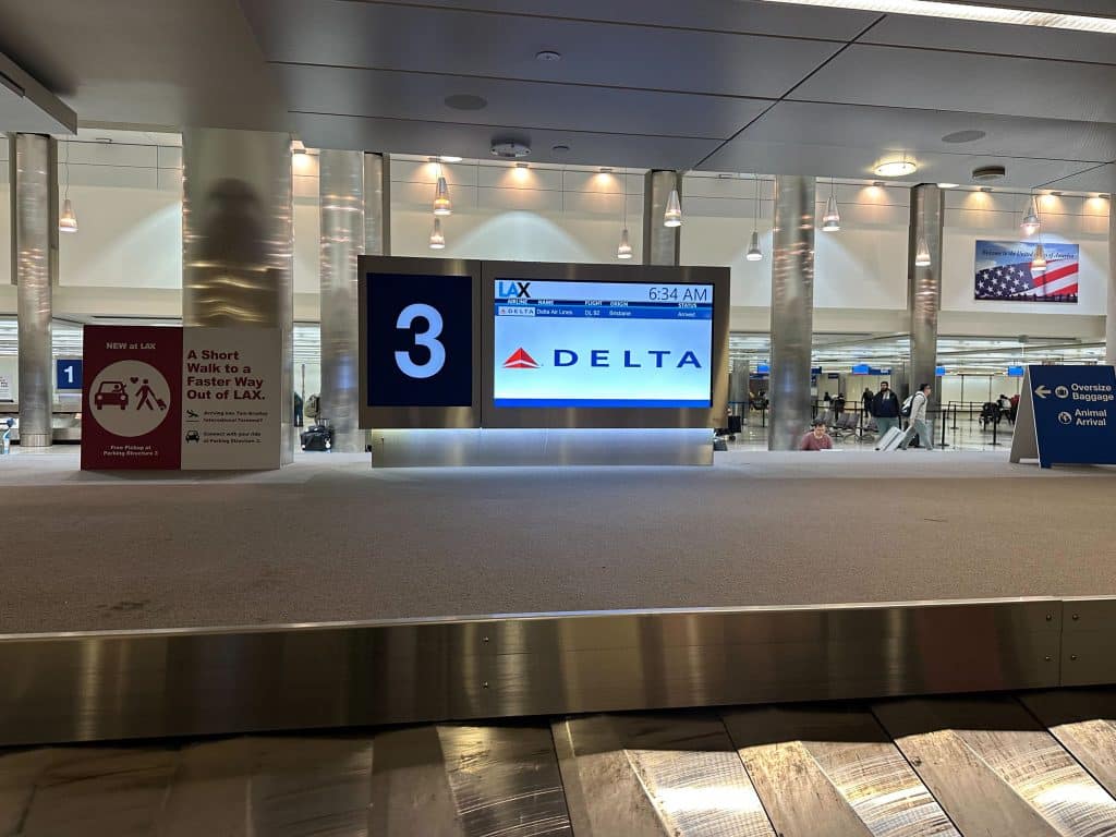 Delta Airlines baggage claim carousel 3 at LAX with Brisbane flight arrival info.