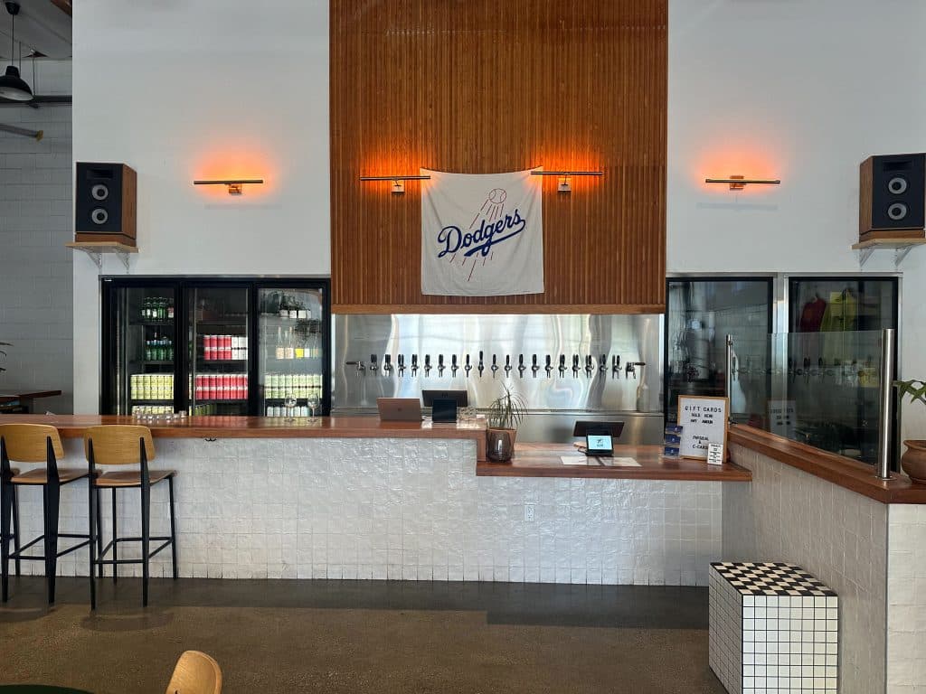 Interior bar at Homage Brewing with a Dodgers flag and beer taps in downtown Los Angeles.
